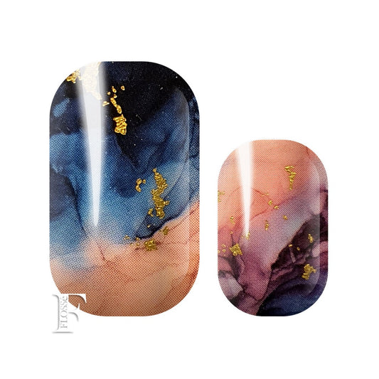 Marbled nail wraps with watercolours of navy blue, pink and purples with gold flecks on top.