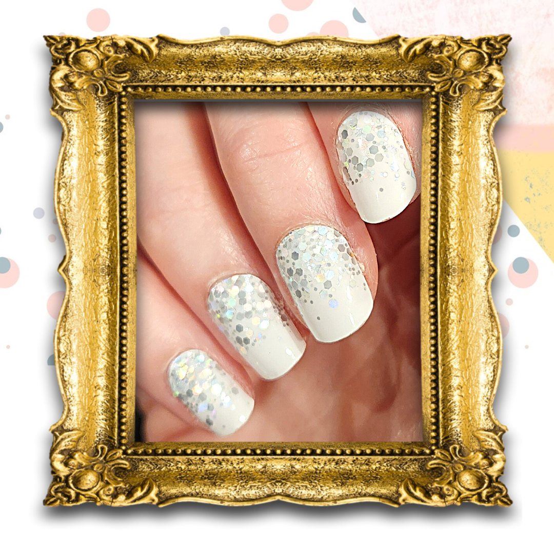 Manicured nails using FLOSSé nail wraps in Snowflake design.  White base with silver holographic sequins
