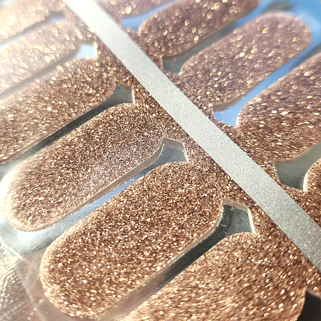 Close up showing bronze glitter on flossé x series Truffling nail wraps. 