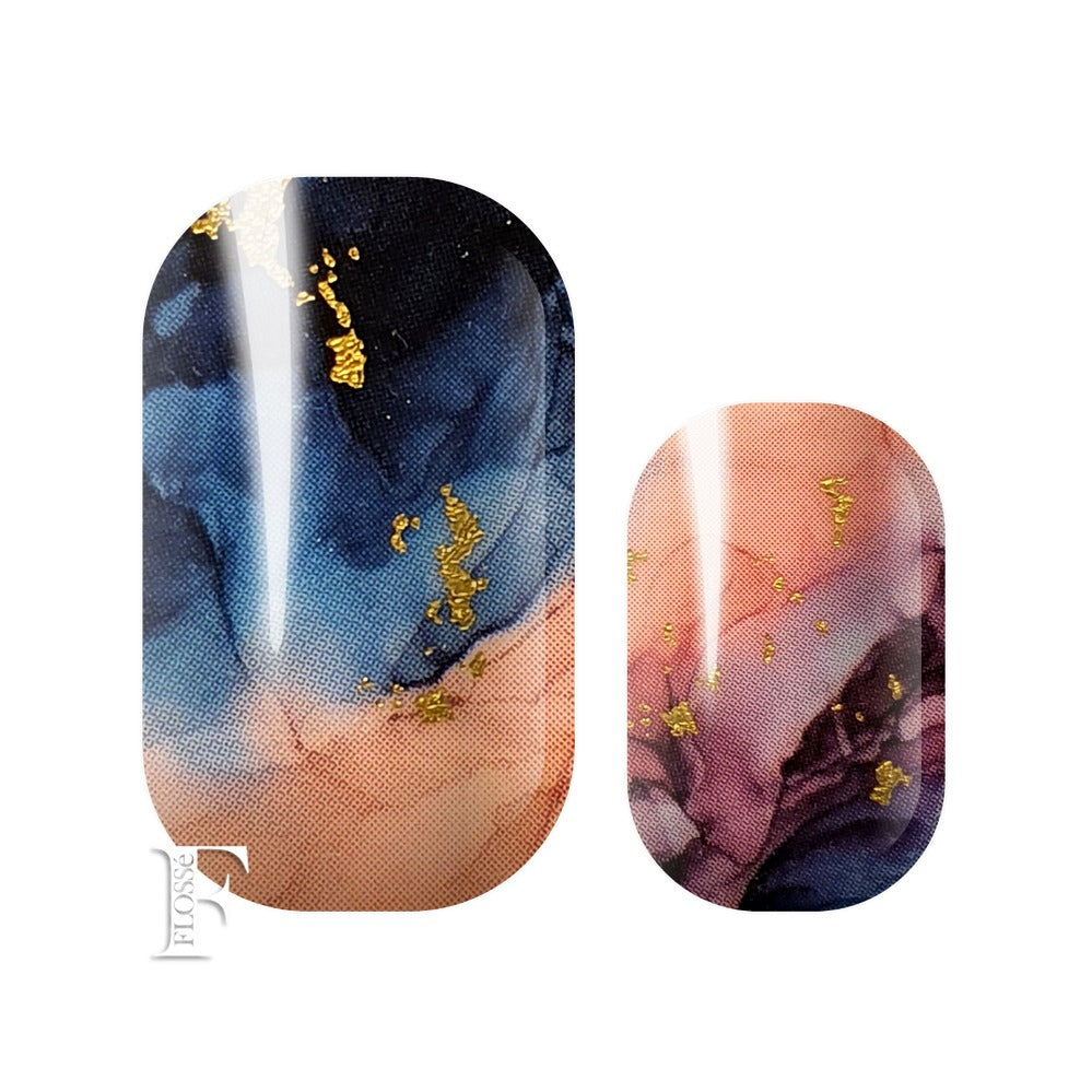 Marbled nail wraps with watercolours of navy blue, pink and purples with gold flecks on top.