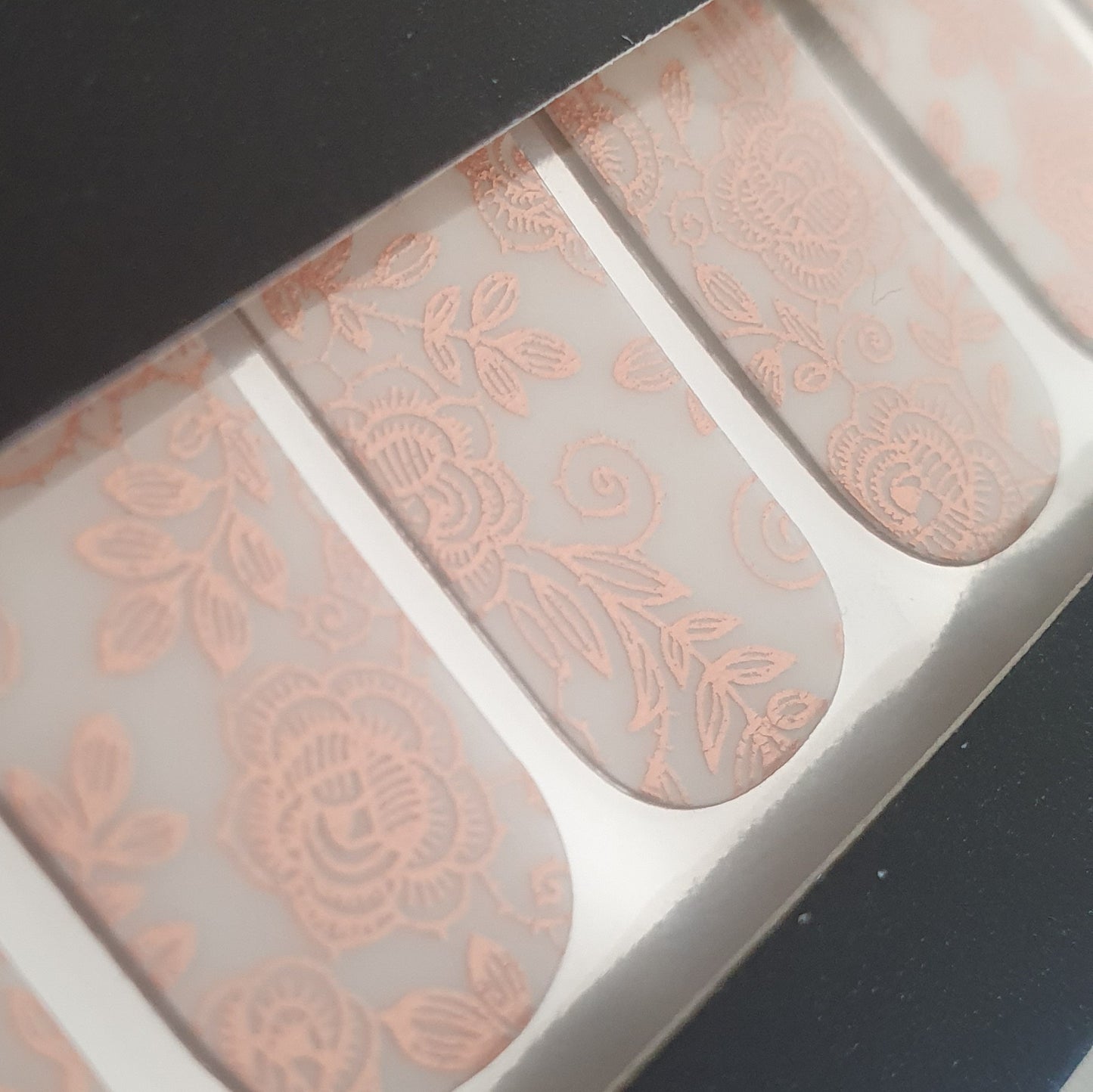 Close up of heritage rose FLOSSé nail wraps. Rose gold foil on translucent base. 