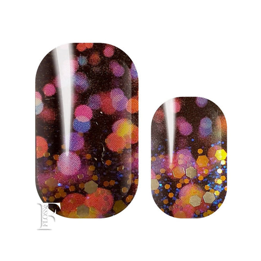 flosse nail wraps nz with dark black base, blotches of bright  colour, gold sequins and blue glitter.