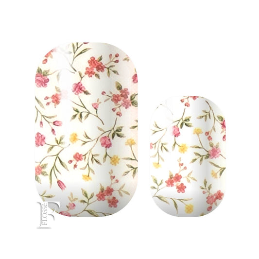 Nail wraps with a white block base topped with delicate small stems of wild flowers in yellow and reddish pink.